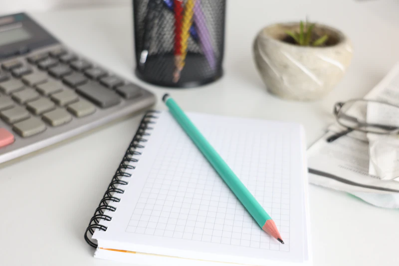 Notebook, pencil and calculator ready for making a money plan
